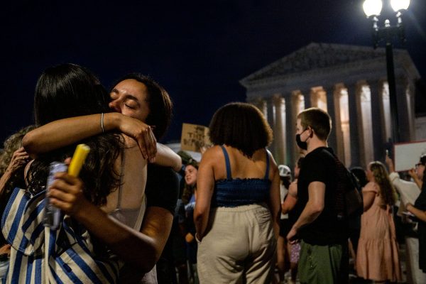 Two protesters hug each other during a candlelight vigil in front of the Supreme Court.