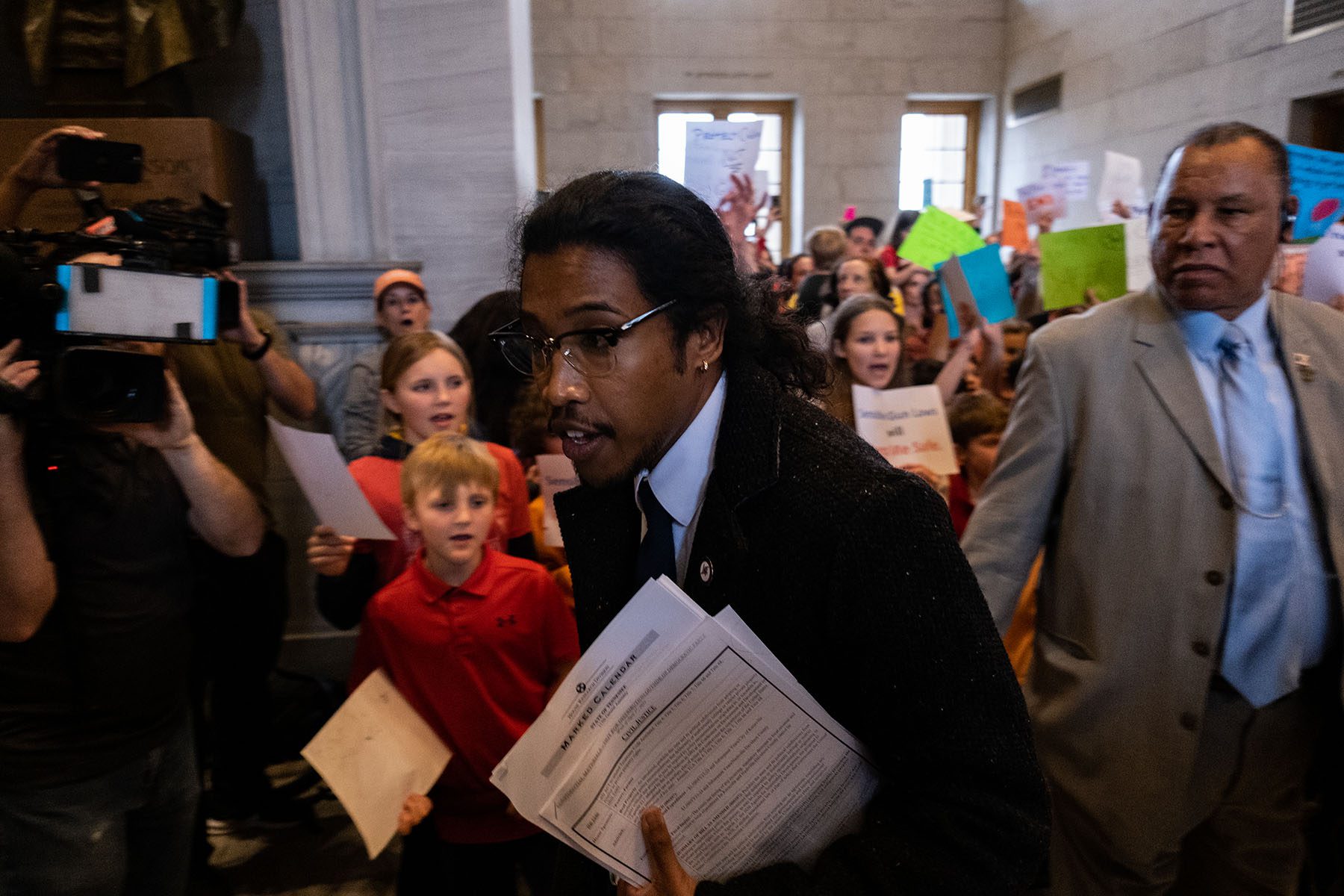 Democratic state Rep. Justin Jones enters the house chamber as protesters chant demanding action for gun reform laws at the Tennessee State Capitol.