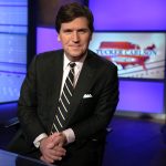 Tucker Carlson poses for photos in a Fox News Channel studio in New York City.