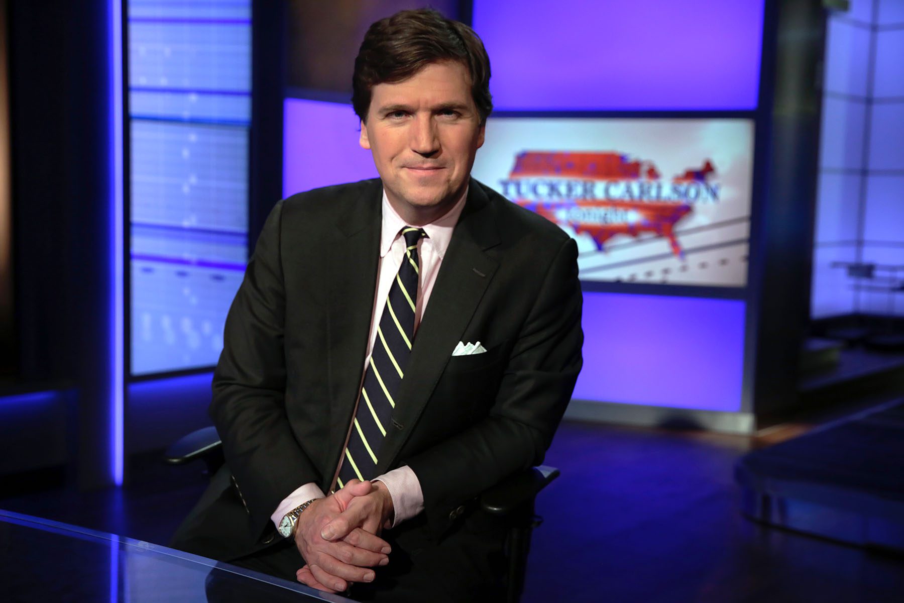 Tucker Carlson poses for photos in a Fox News Channel studio in New York City.