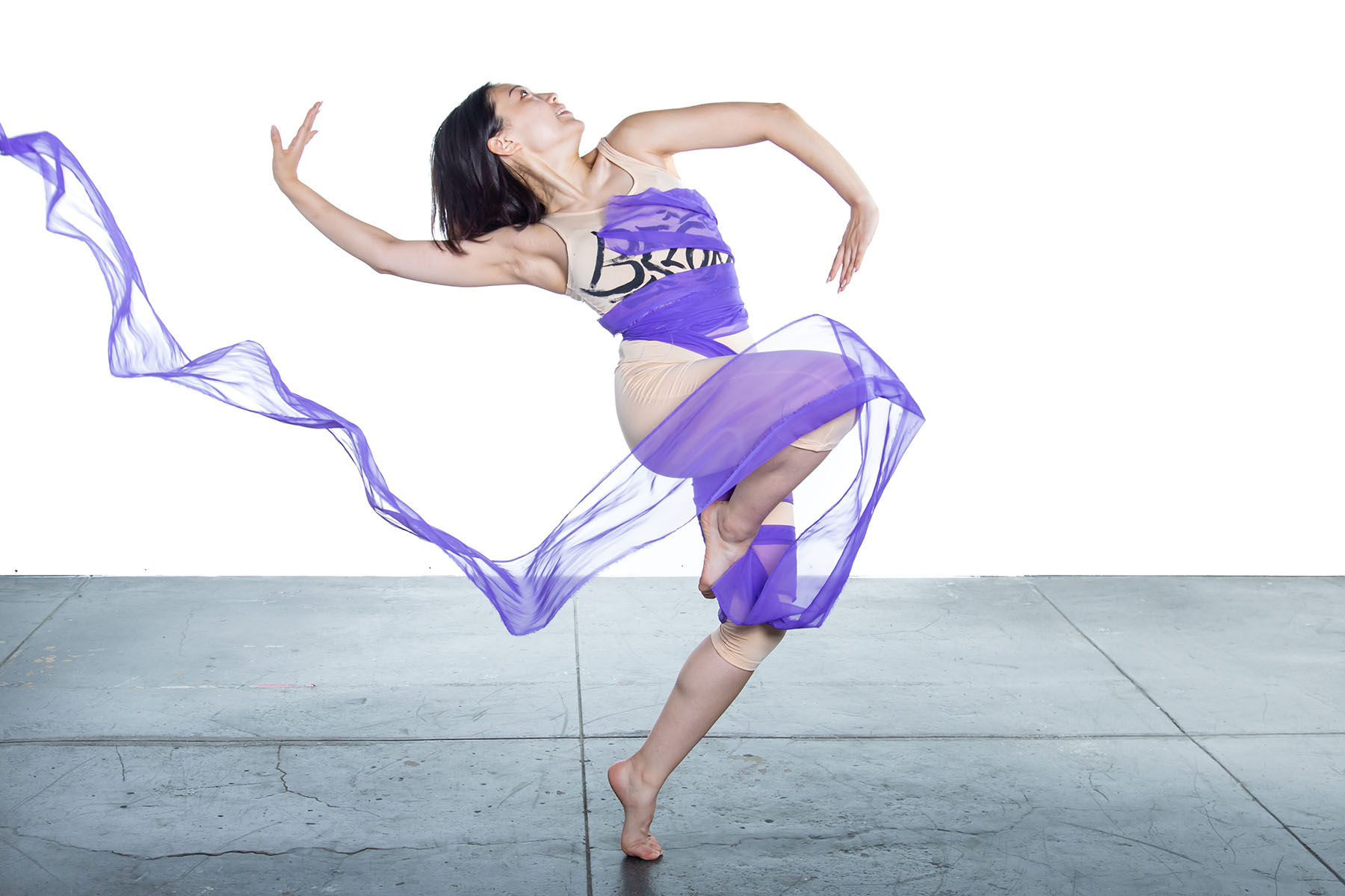Hayoung Roh, member of the J Chen Company, is seen performing with a long piece of purple tule.