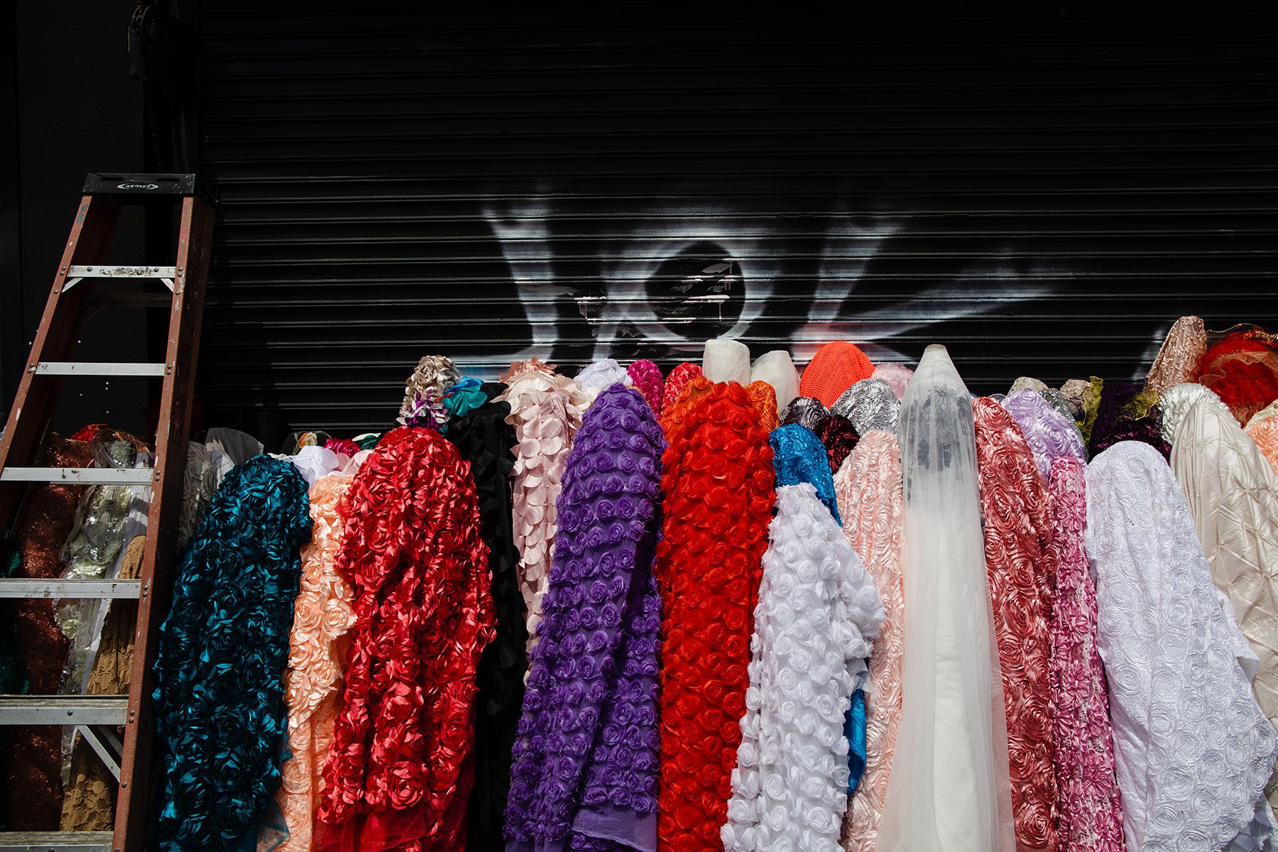 Colorful rolls of fabric sit on the sidewalk outside one of the Fashion District's many shops.