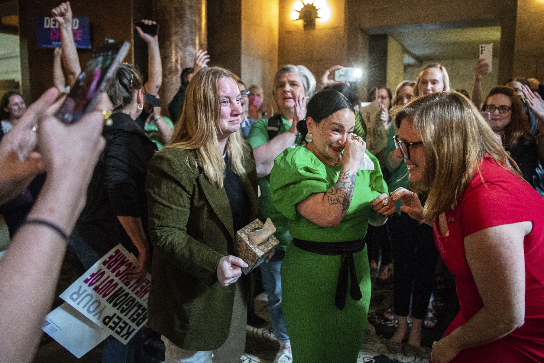 State Sens. Megan Hunt, Jen Day and Sen. Machaela Cavanaugh embrace while being cheered on by supporters after a bill seeking to ban abortions in Nebraska after about six weeks failed to advance.
