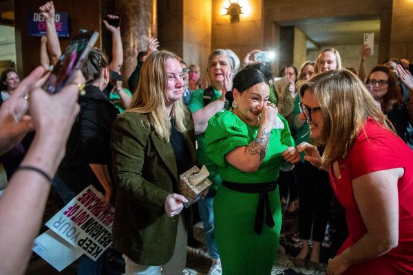 State Sens. Megan Hunt, Jen Day and Sen. Machaela Cavanaugh embrace while being cheered on by supporters after a bill seeking to ban abortions in Nebraska after about six weeks failed to advance.