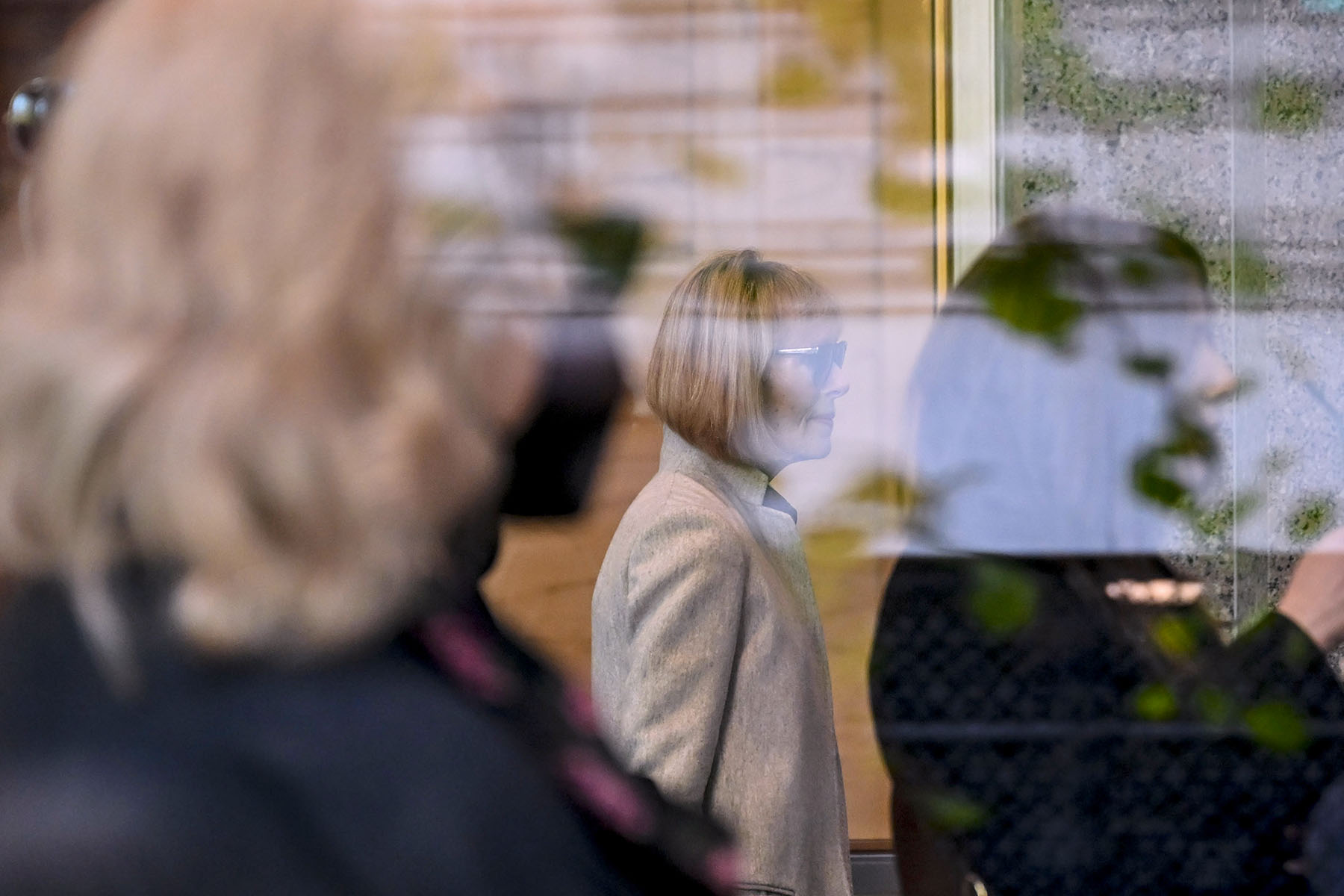 E. Jean Carroll is seen through a window as she arrives for the first day of her civil trial against former President Donald Trump.