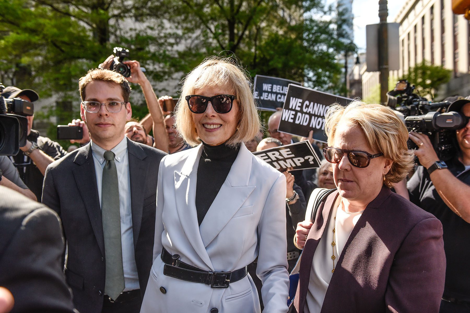E. Jean Carroll leaves following her trial at Manhattan Federal Court as supporters hold signs and cheer around the courthouse.
