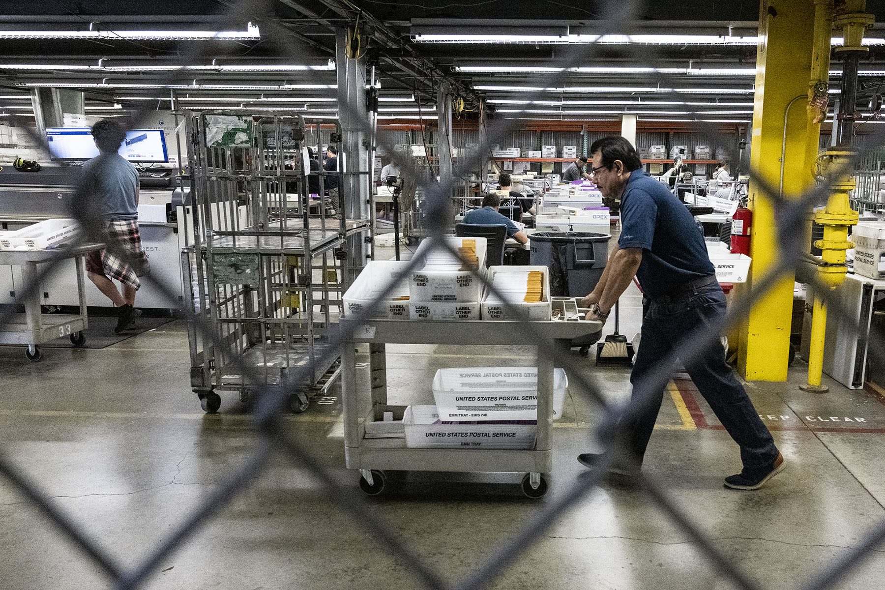 Employees at the Orange County Registrar of Voters extract and sort ballots in a secure area in Santa Ana, California.