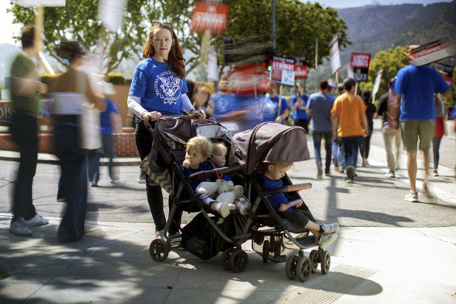 Hollie Overton, member of the Writers Guild of America, poses with her children while on strike near The Walt Disney Studios.