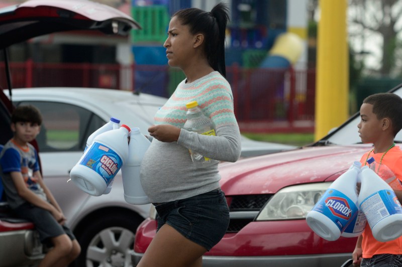 A pregnant woman in Puerto Rico picks up cleaning supplies after Hurricane Maria