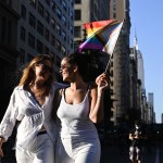 Two women waving a Pride flag participate in the 30th Annual New York City Dyke March.