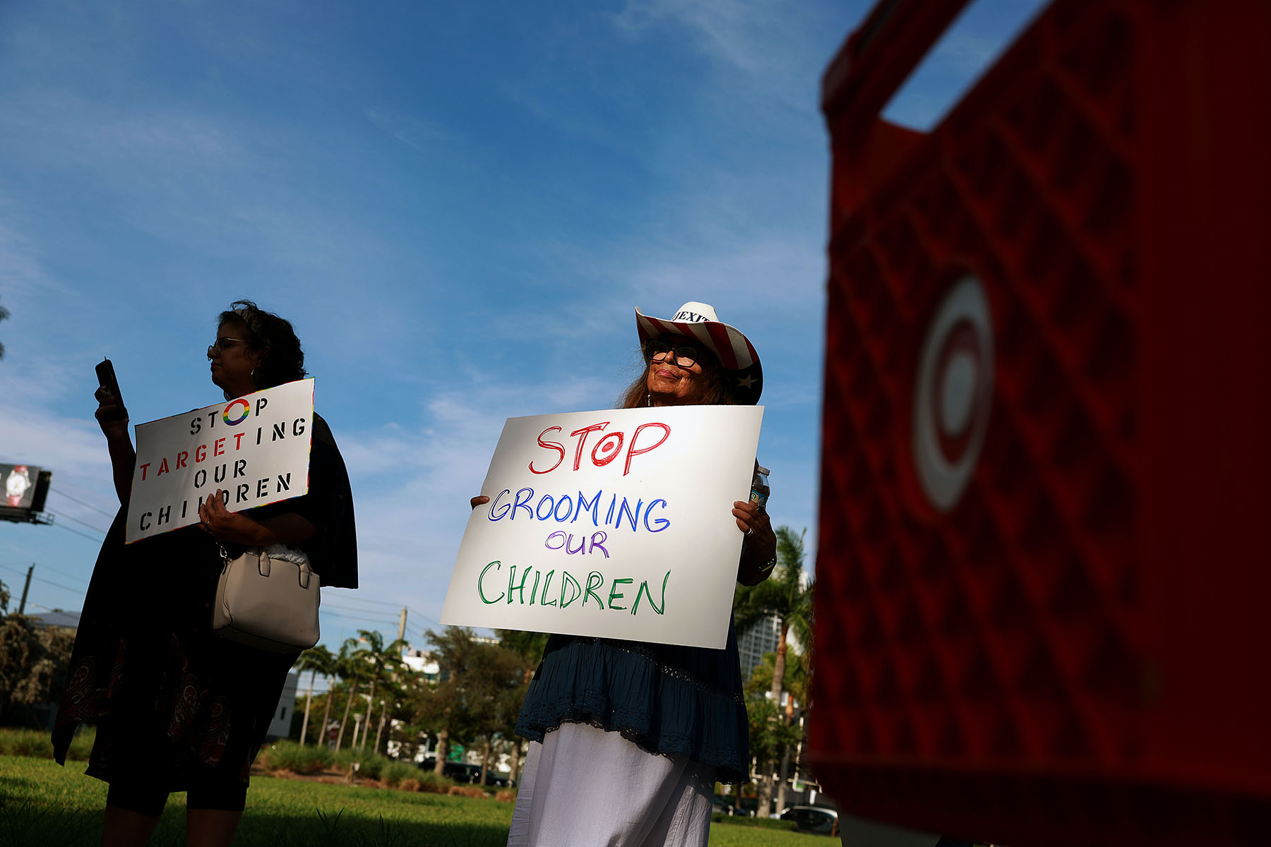 People protest Target's Pride Month merchandise outside of a Target store in Miami. They hold signs that read "Stop targeting our children" and "Stop grooming our children."