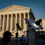 A news crew stands outside of the United States Supreme Court.
