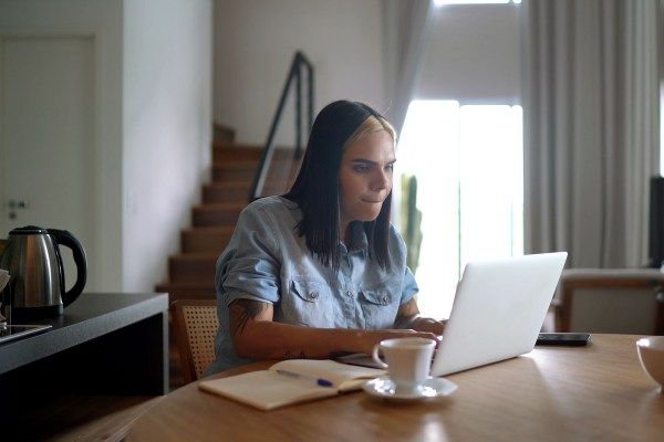 A transgender woman uses a laptop to work from home.