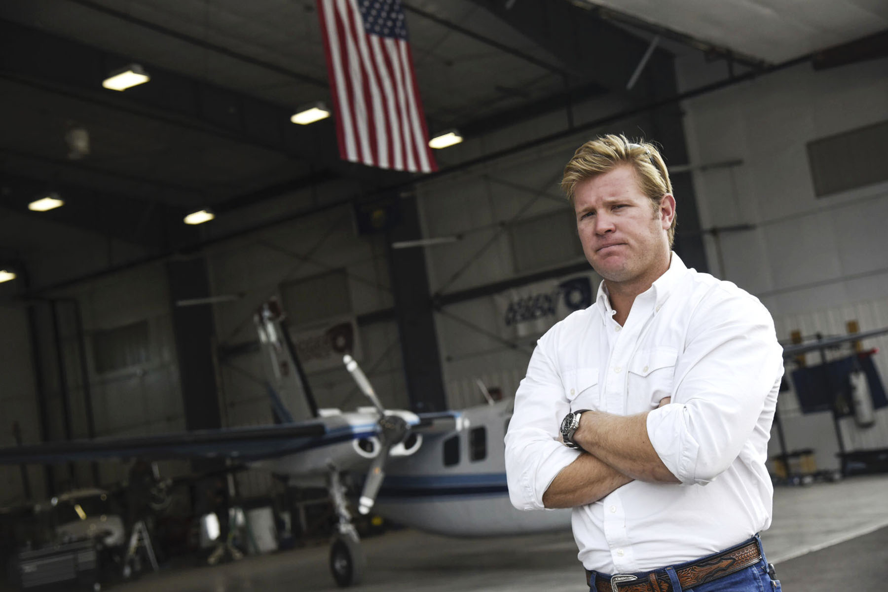 Tim Sheehy poses for a portrait in a plane hangar.