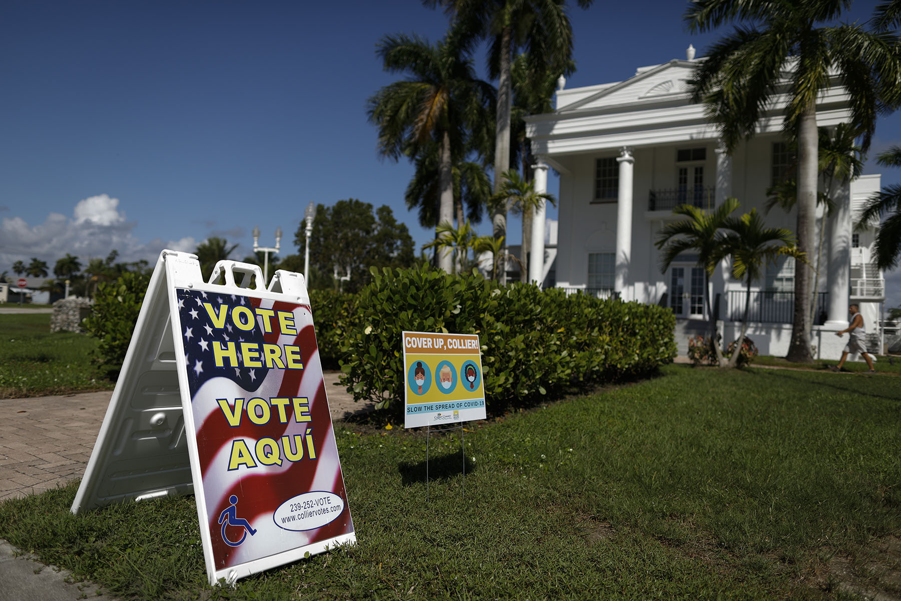 A voting sign in english and spanish is seen as a man walks into City Hall in Everglades City, Florida.