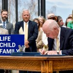 Montana Gov. Greg Gianforte signs a suite of bills aimed at restricting access to abortion during a bill signing ceremony on the steps of the state Capitol.