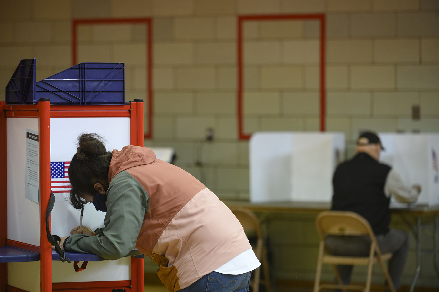 A voter fills in her ballot during primary voting.