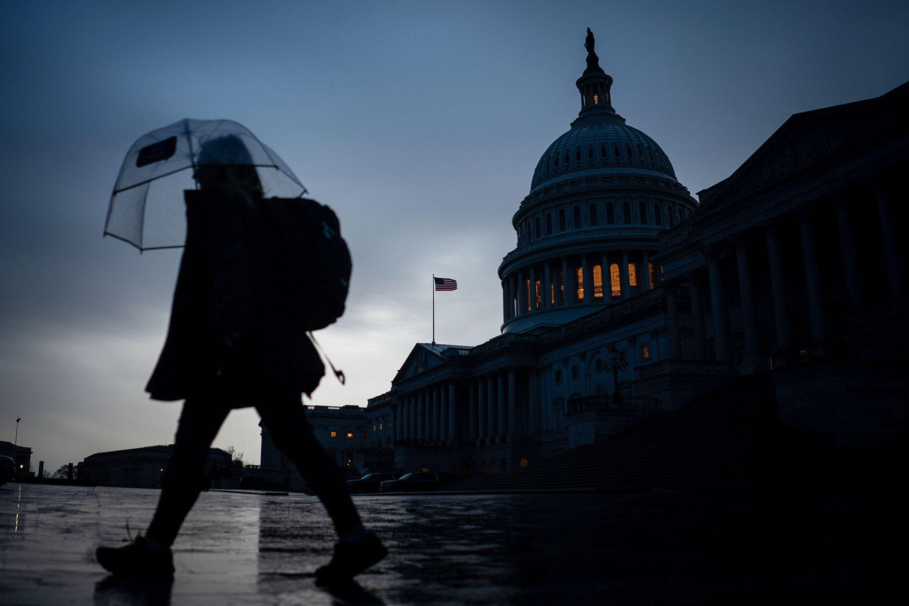 A pedestrian walks through the Capitol Plaza with the dome of the U.S. Capitol Building as a backdrop.