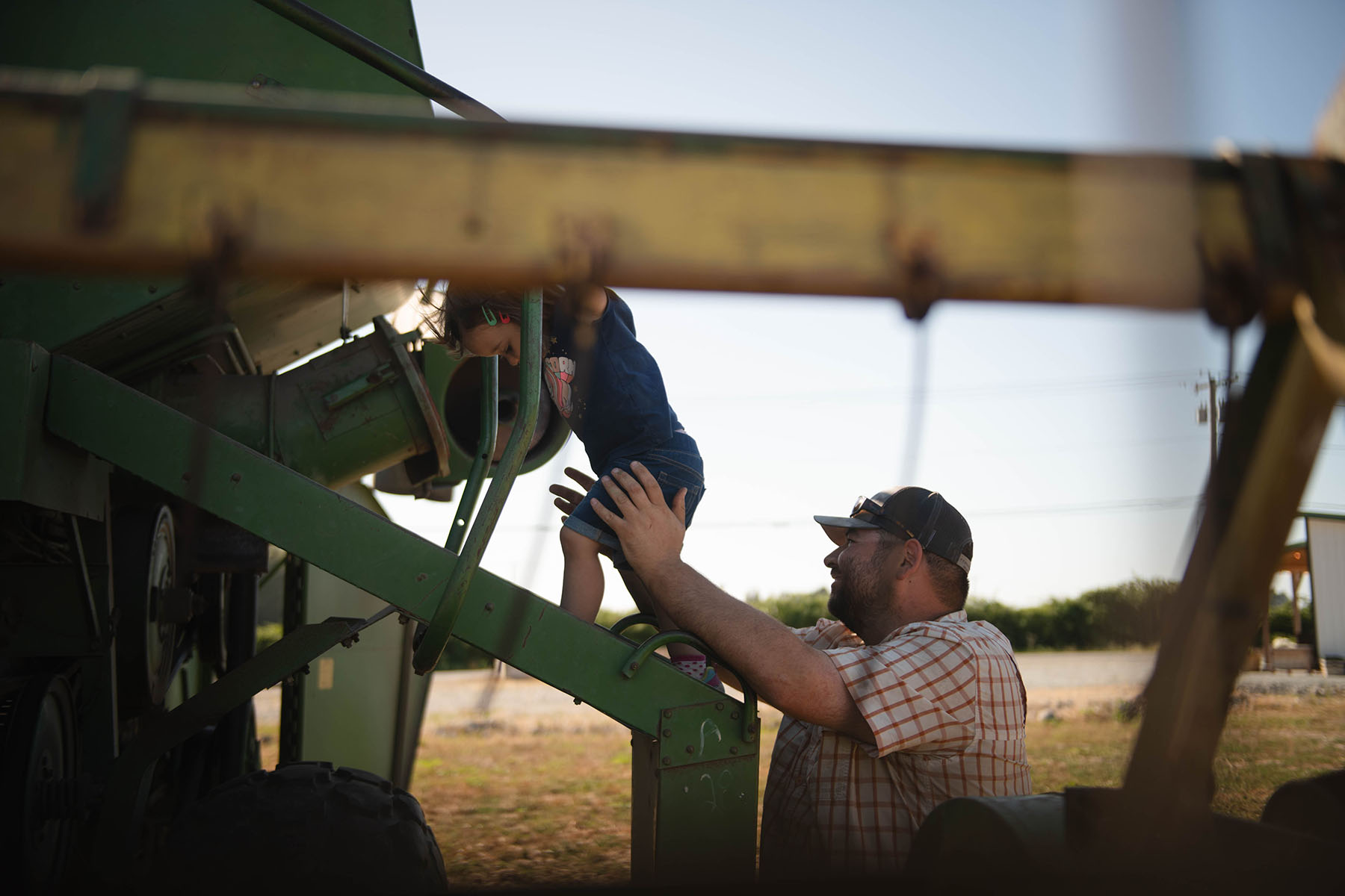 Jacob Slosberg plays with daughter Ayla on a tractor.