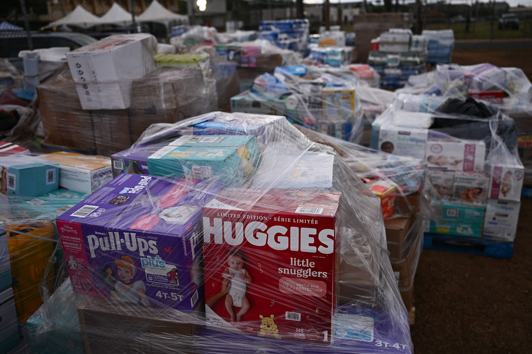 Donated goods including diapers await distribution outside of a shelter.