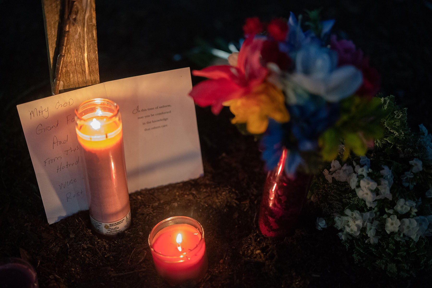 A candle burns at a memorial for Anolt Joseph Laguerre Jr. near the Dollar General store where he was shot and killed.