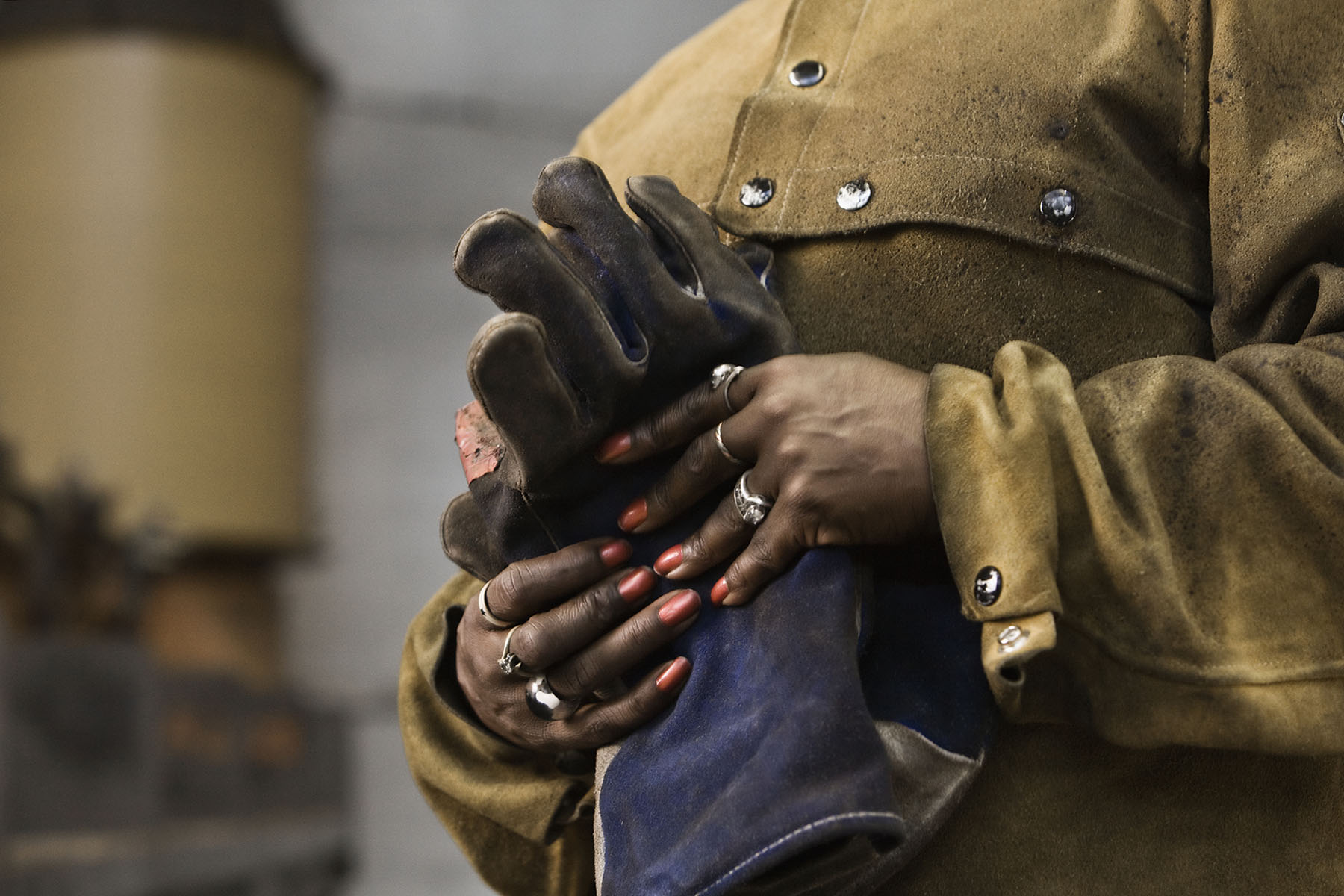 Close up of hands and gloves of black female welder.