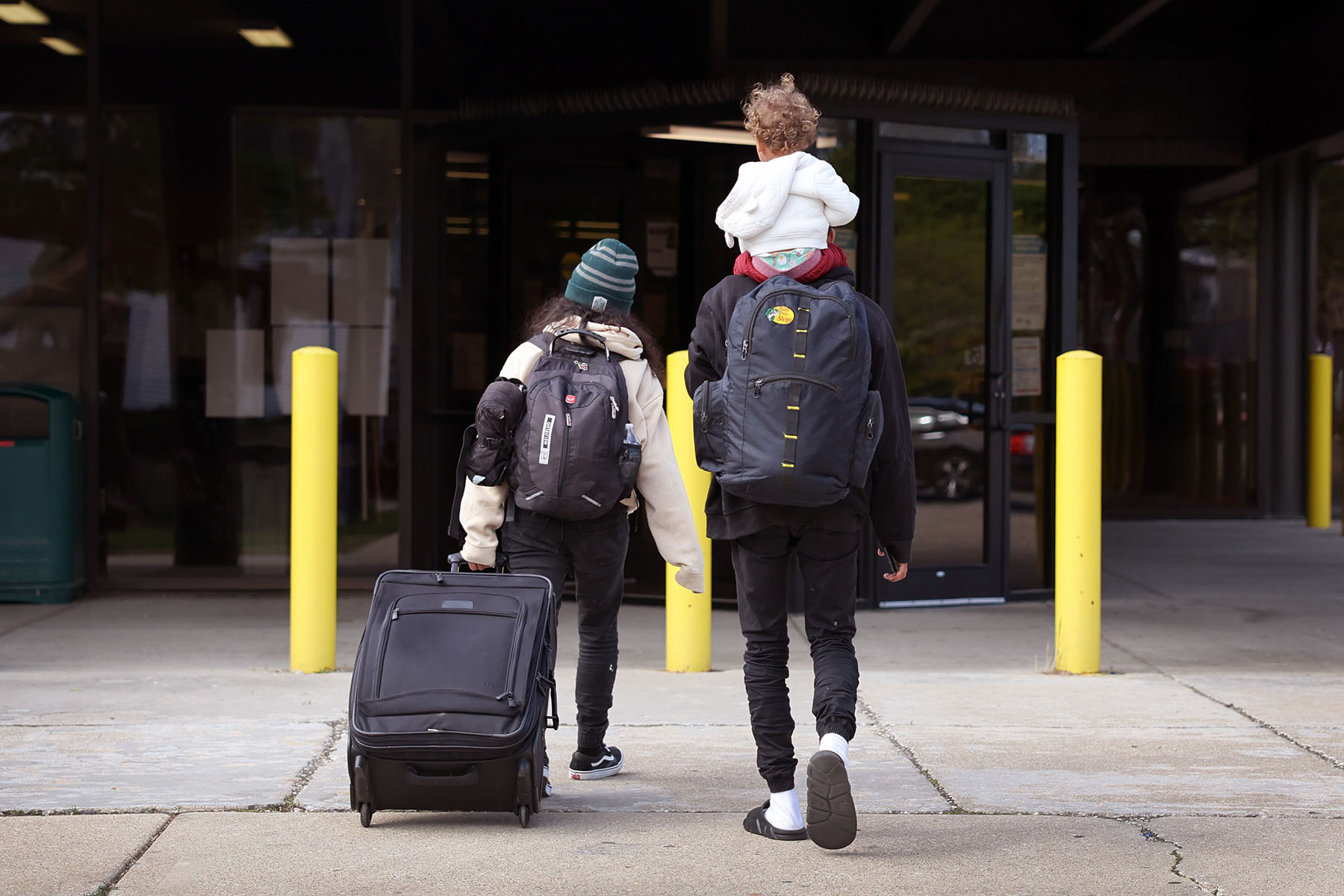 A migrant family arrives at a police station with their belongings.