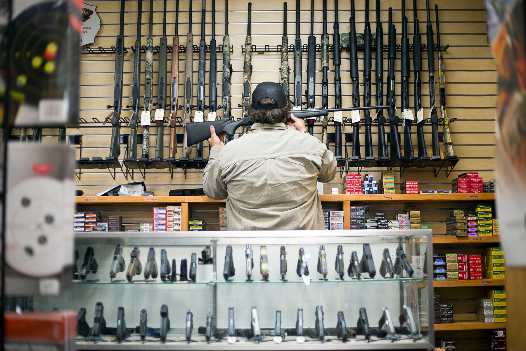 A sales person removes a rifle from the wall of a gun shop in Colorado.