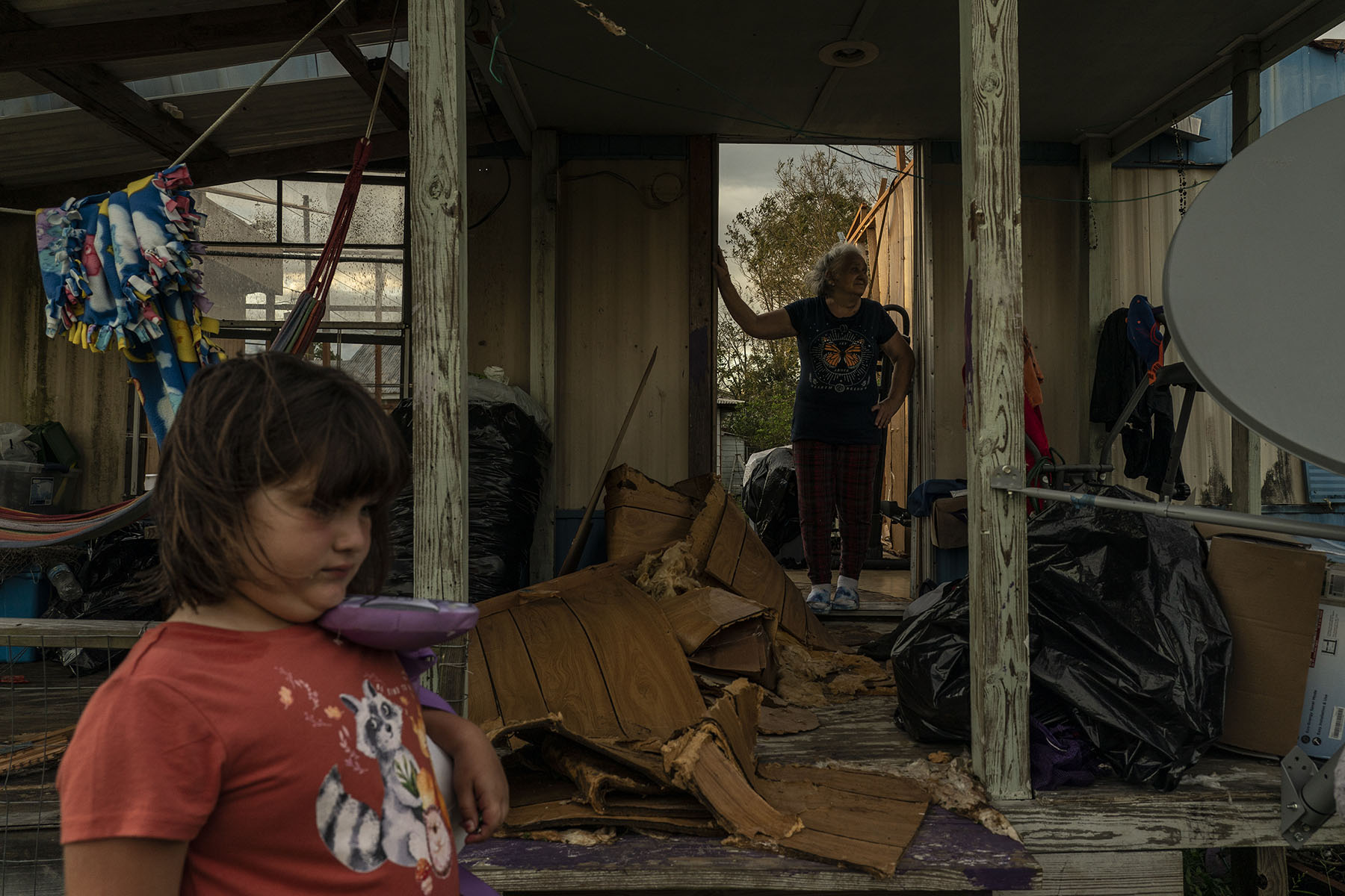 A family stands in the ruins of their home after the Hurricane Ida passed through Houma, Louisiana.
