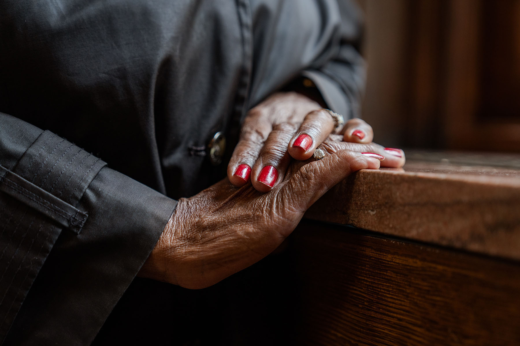 A close up of Althea Garrison's hands. She is wearing red nail polish and a diamond ring.