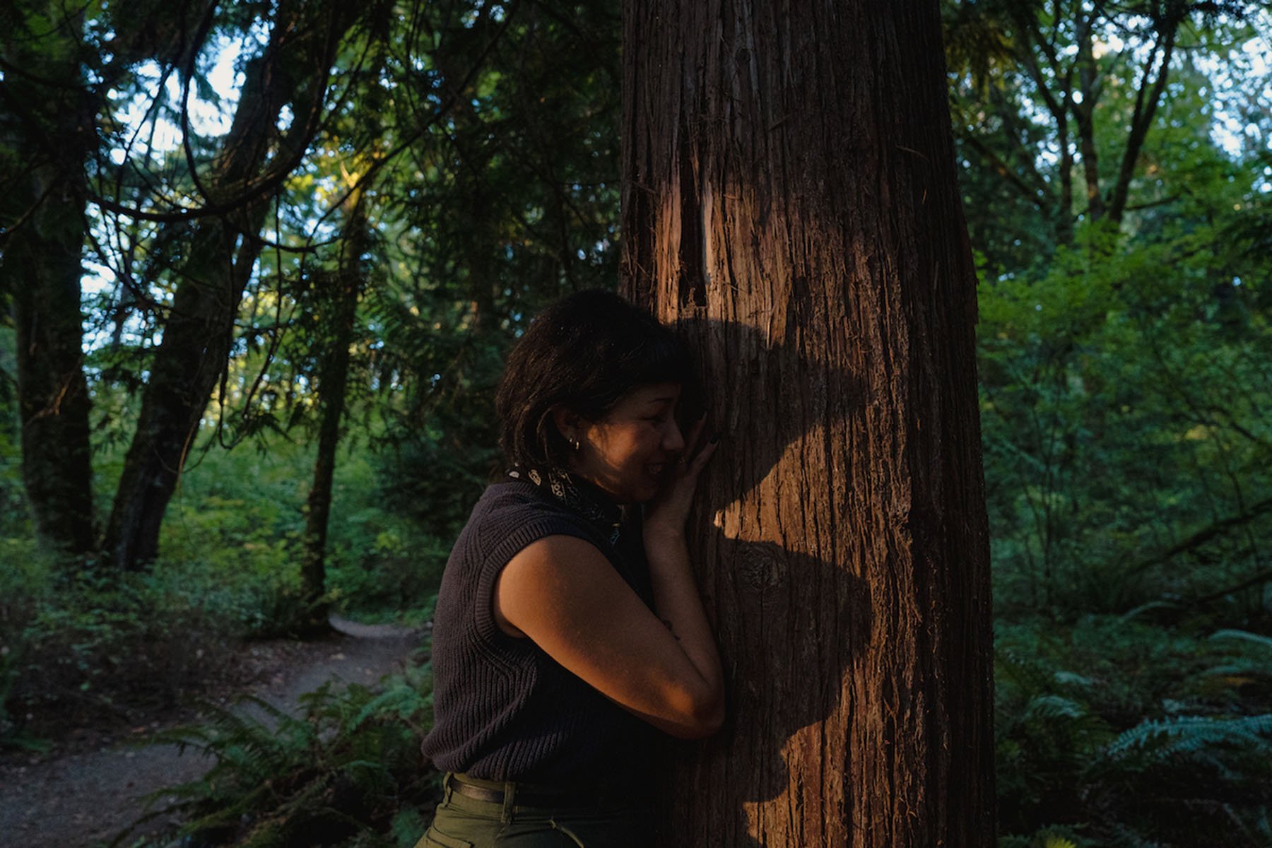 Michelle Barboza “MB” Ramirez hugs a red cedar tree at Seward Park in Seattle, Washington.