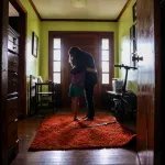 Marie gives one of her gender non-confirming children a hug in the doorway of their home.