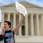 A demonstrator outside the Supreme Court in Washington, D.C. wears a 