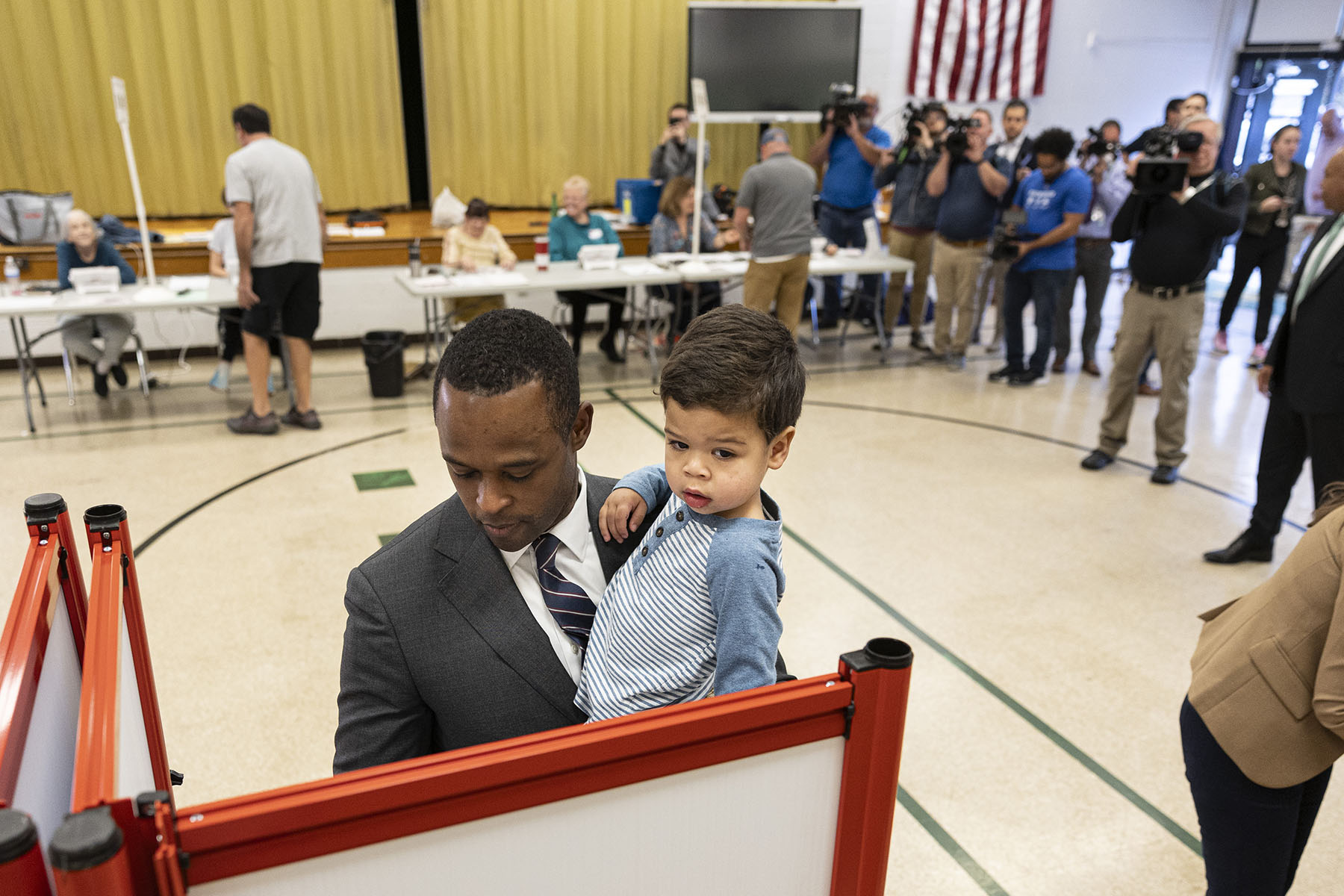 Attorney General Daniel Cameron casts his vote for governor as he holds his son.