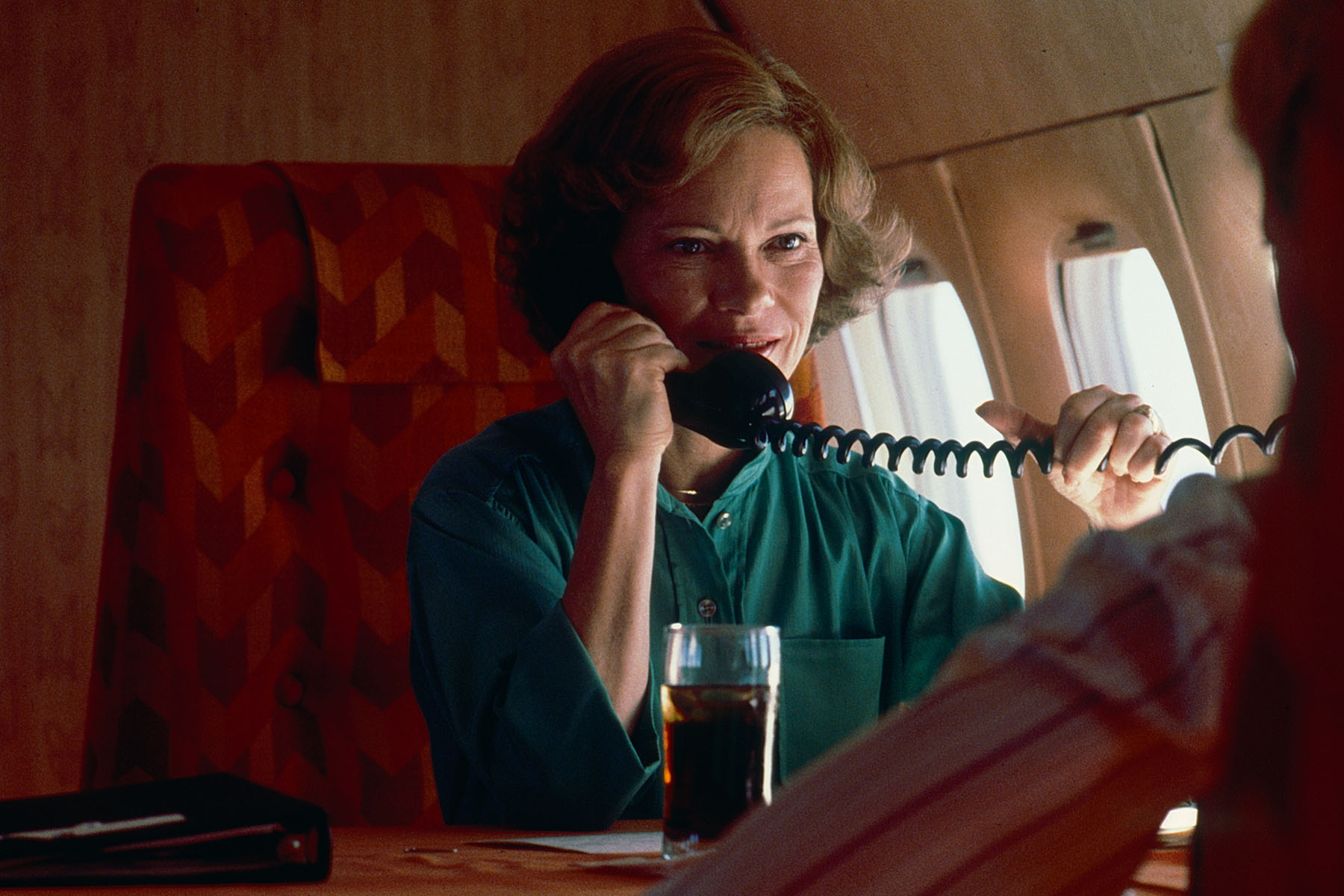 First Lady Rosalynn Carter talks on the telephone in a plane as she returns home from a campaign trip to Florida.