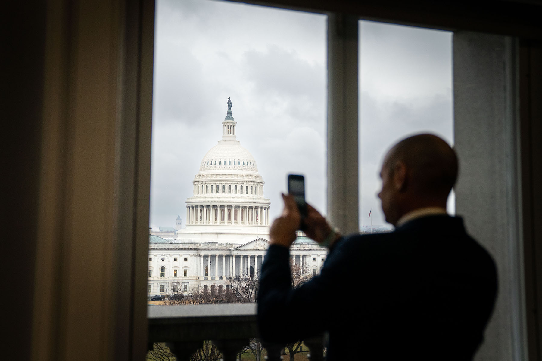 A person standing at a window takes a photograph of the East Plaza of the U.S. Capitol from the Library of Congress.
