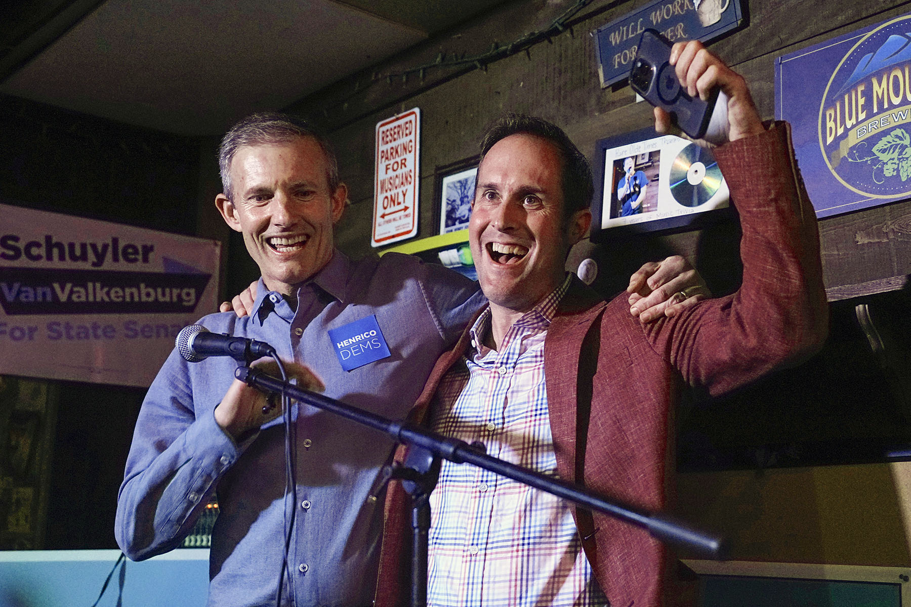 Democrats Del. Schuyler VanValkenburg, (right) and Del. Rodney Willett celebrate on stage at an election party in Richmond, Virginia.