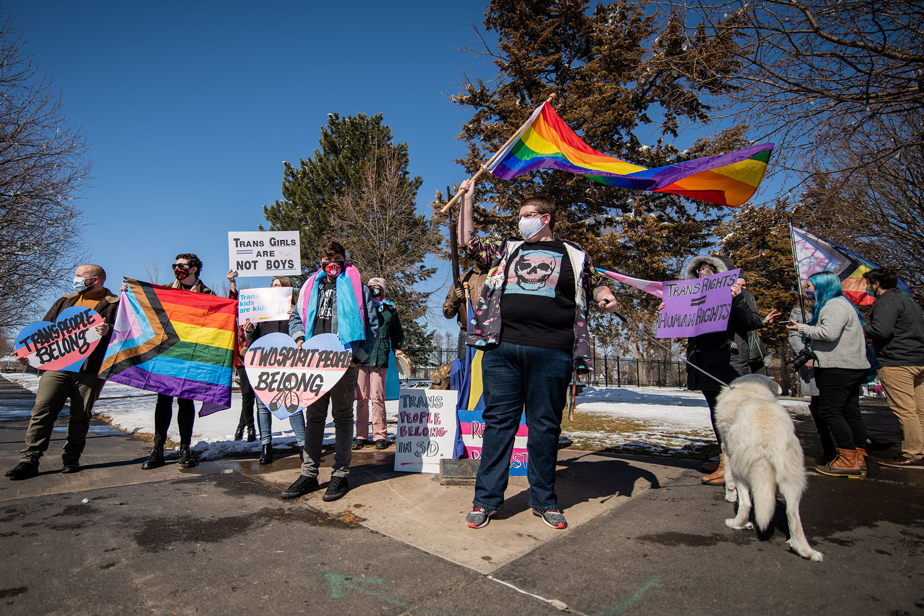 People waving flags and signs protest anti-trans bill in Pierre, South Dakota.
