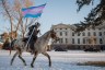 An indigenous protester rides across the South Dakota Capitol lawn on horseback.