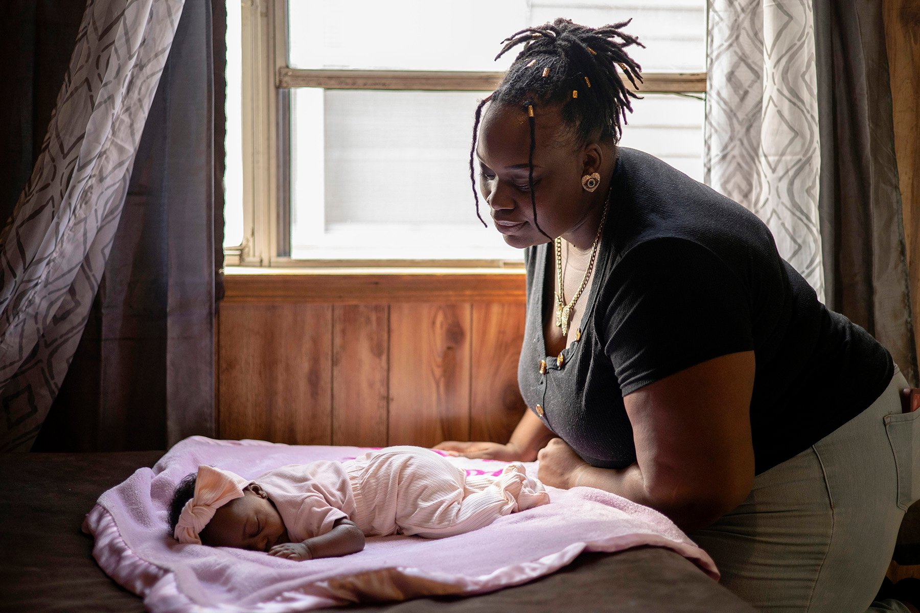 O'Laysha Davis looks down at her 3-month-old daughter, Journee’ Divine Stokes, while she sleeps.