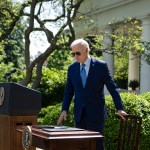 President Biden steps towards a table and chair as he prepares to sign an executive order in the Rose Garden of the White House.