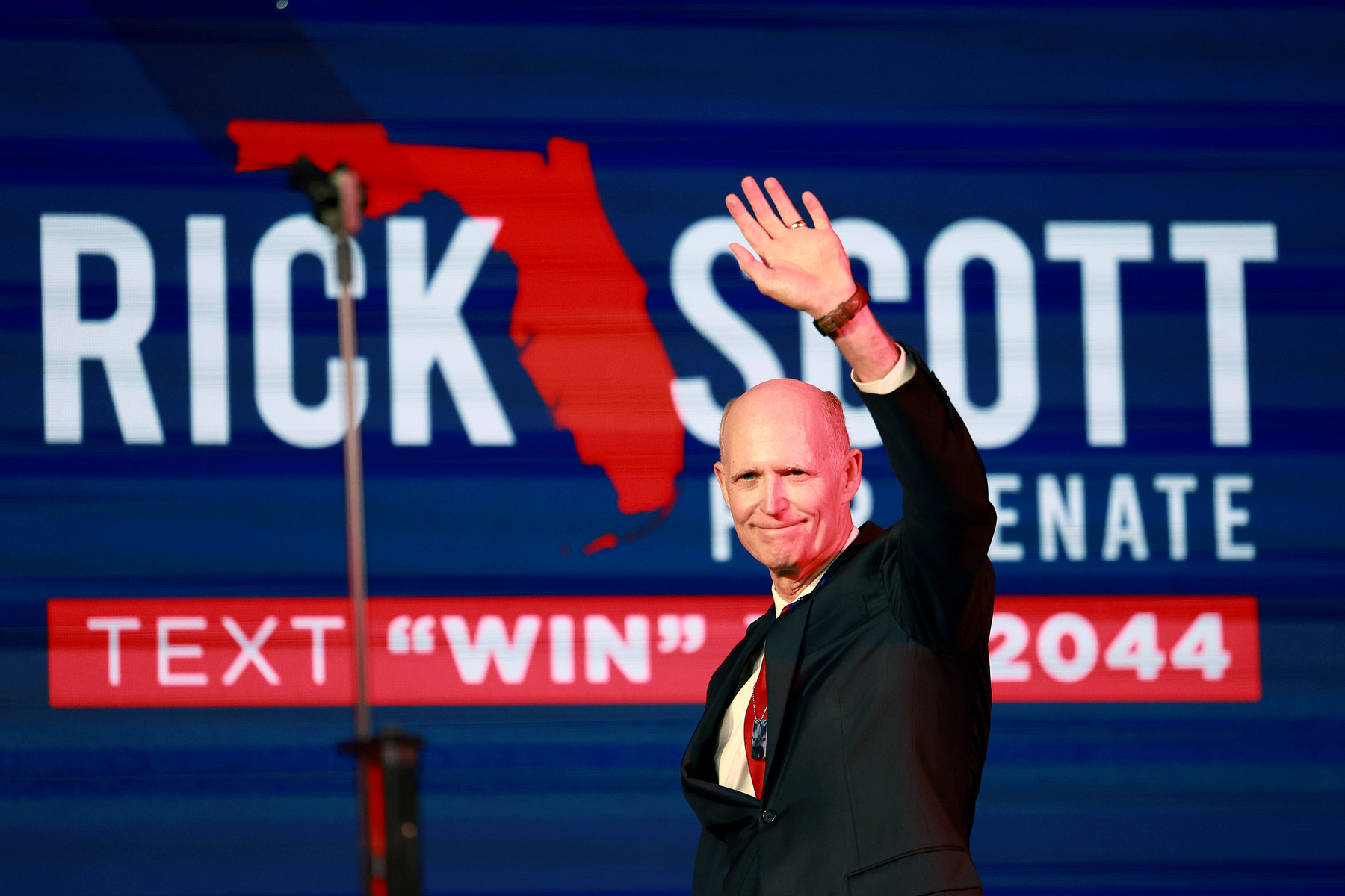 Sen. Rick Scott waves at a crowd during an event.