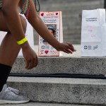 A participant reaches for a luminary bag displaying the photo of a loved one, during the American Foundation for Suicide Prevention Overnight Walk near the Lincoln Memorial in Washington, D.C., on Saturday, June 3, 2023.
