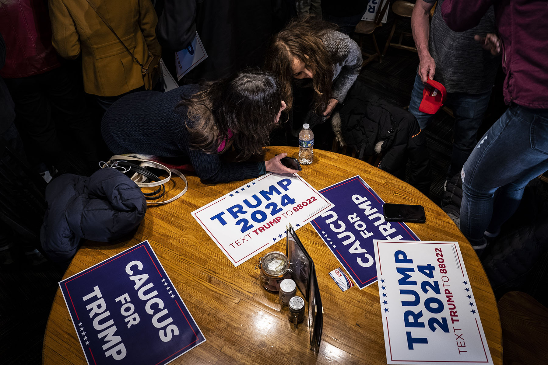 Donald Trump supporters chat ahead of the Iowa Republican caucuses in January 2024, in Urbandale, Iowa.