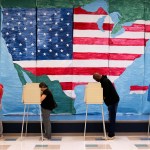Voters fill out their ballots in front of a giant map of the United States at a polling station on November 7, 2023.