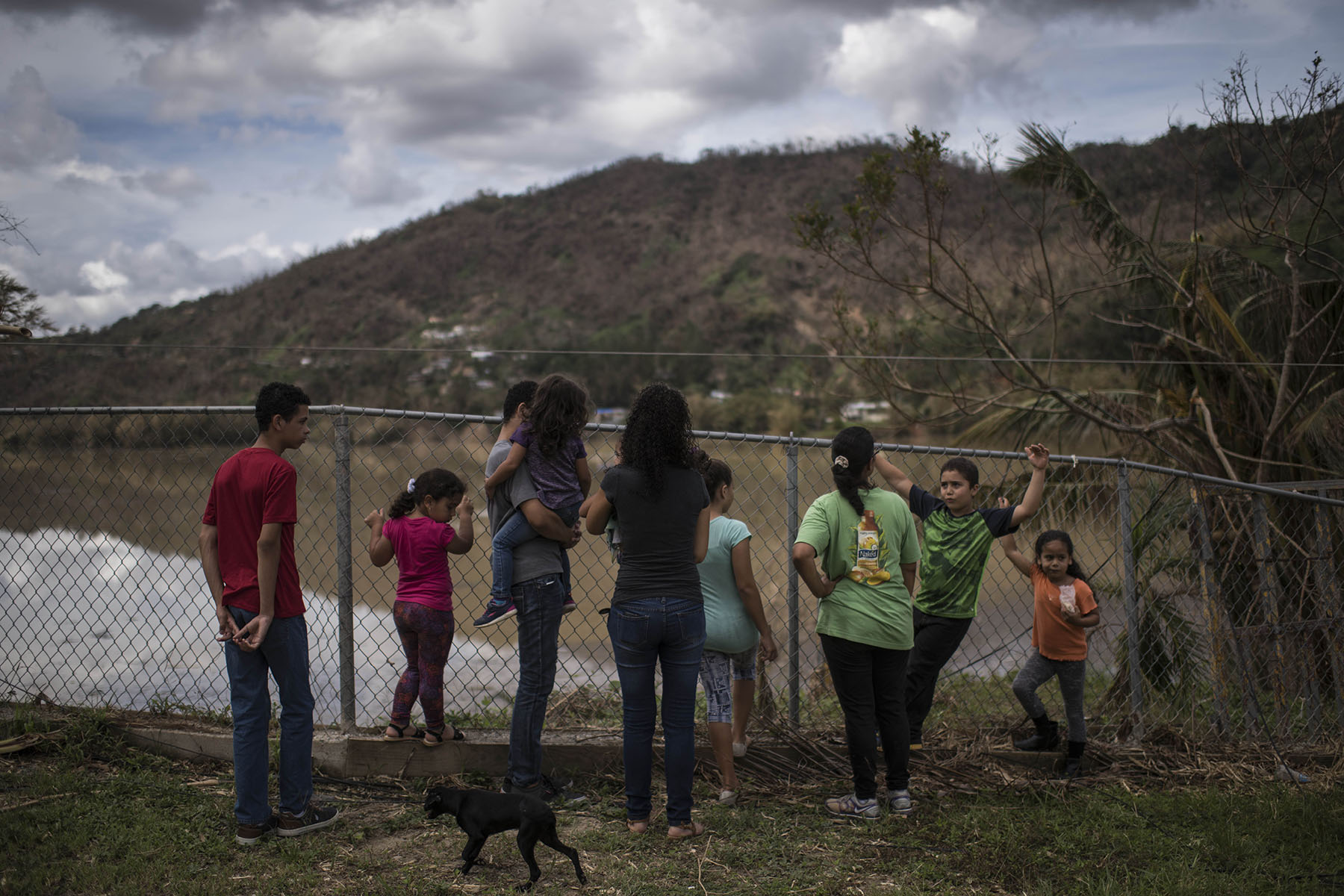 A family, waiting for church services to begin, peer out at Lake Canonillas in the hurricane ravaged town of Caonillas, Puerto Rico.