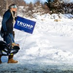 A Donald Trump supporter carries her baby and a Trump placard as she braves the below zero temperatures to attend a rally in Indianola, Iowa.