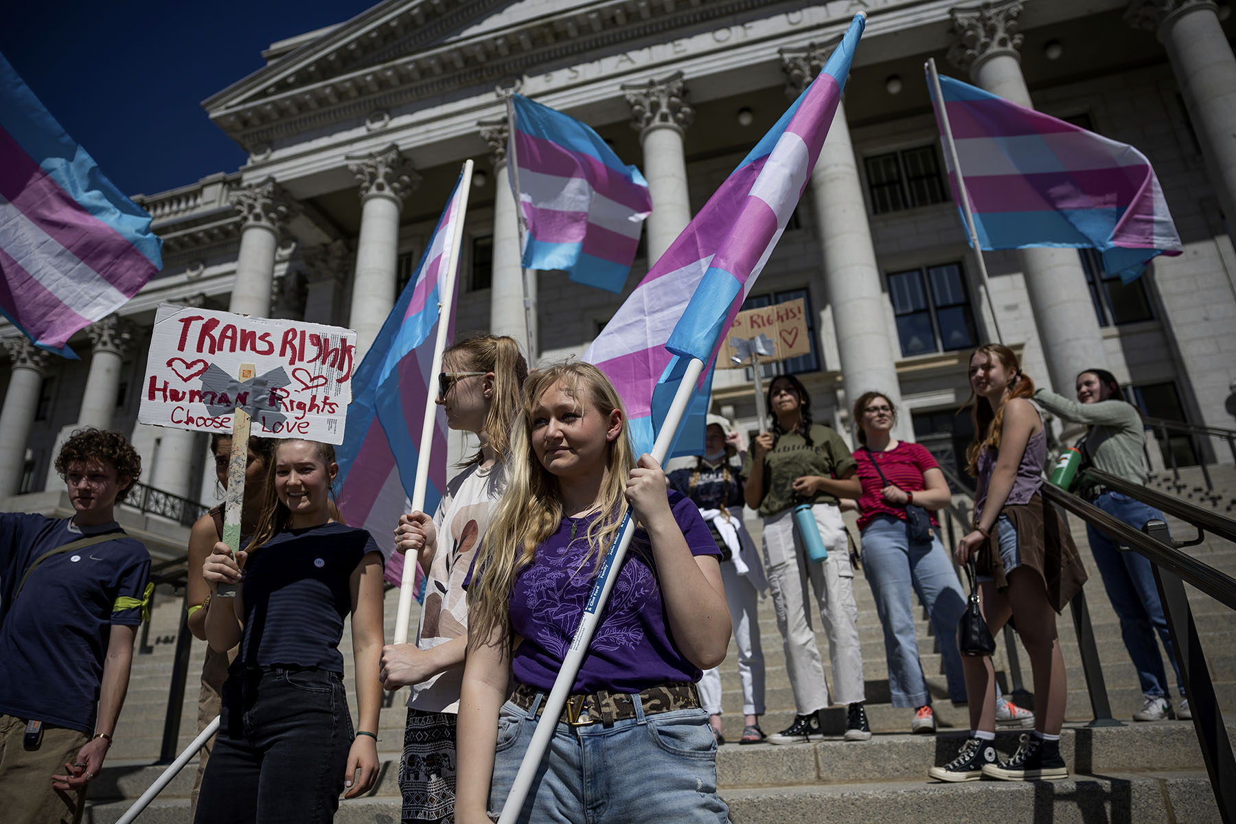Protesters holding transgender pride flags demonstrate in front of the Utah Captiol.