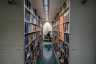 A student is seen reading between stacks of books at the Rice University Library.