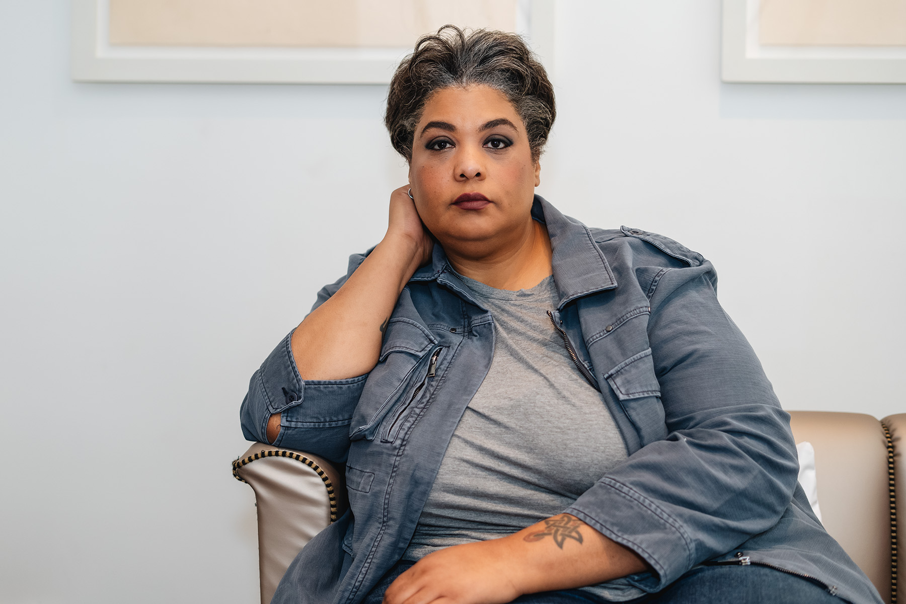 Portrait of Roxane Gay sitting on a couch.